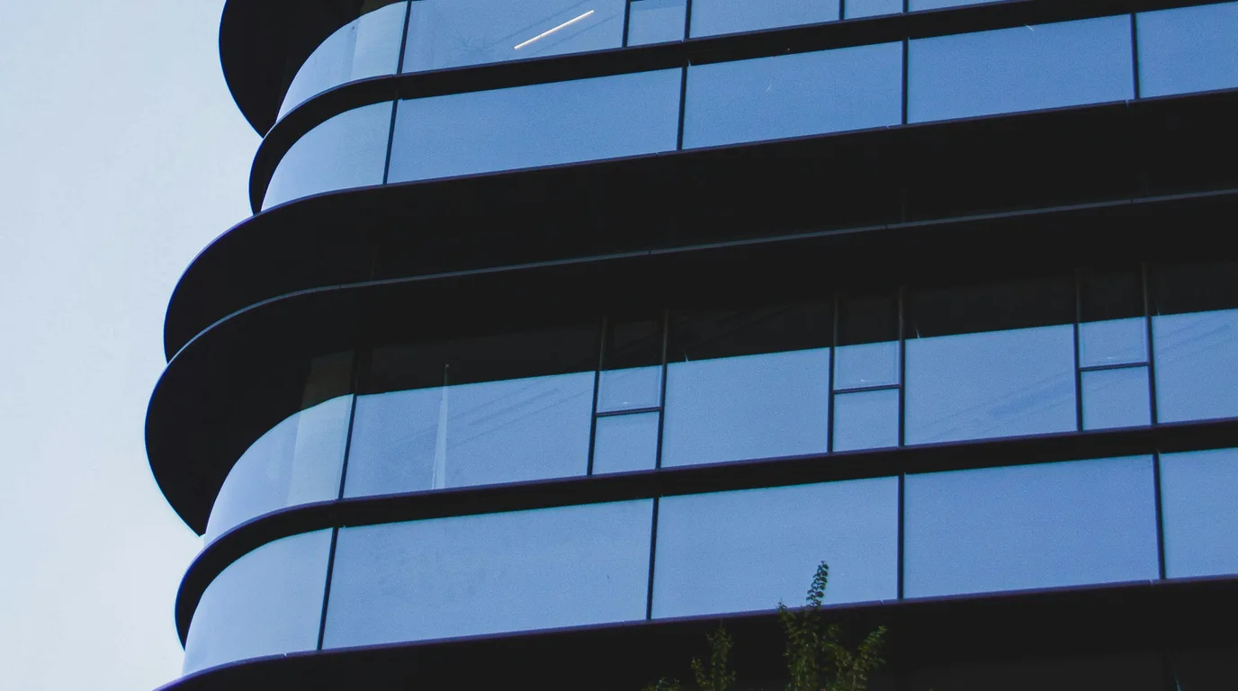 Curved office tower banded in black and tinted blue glass